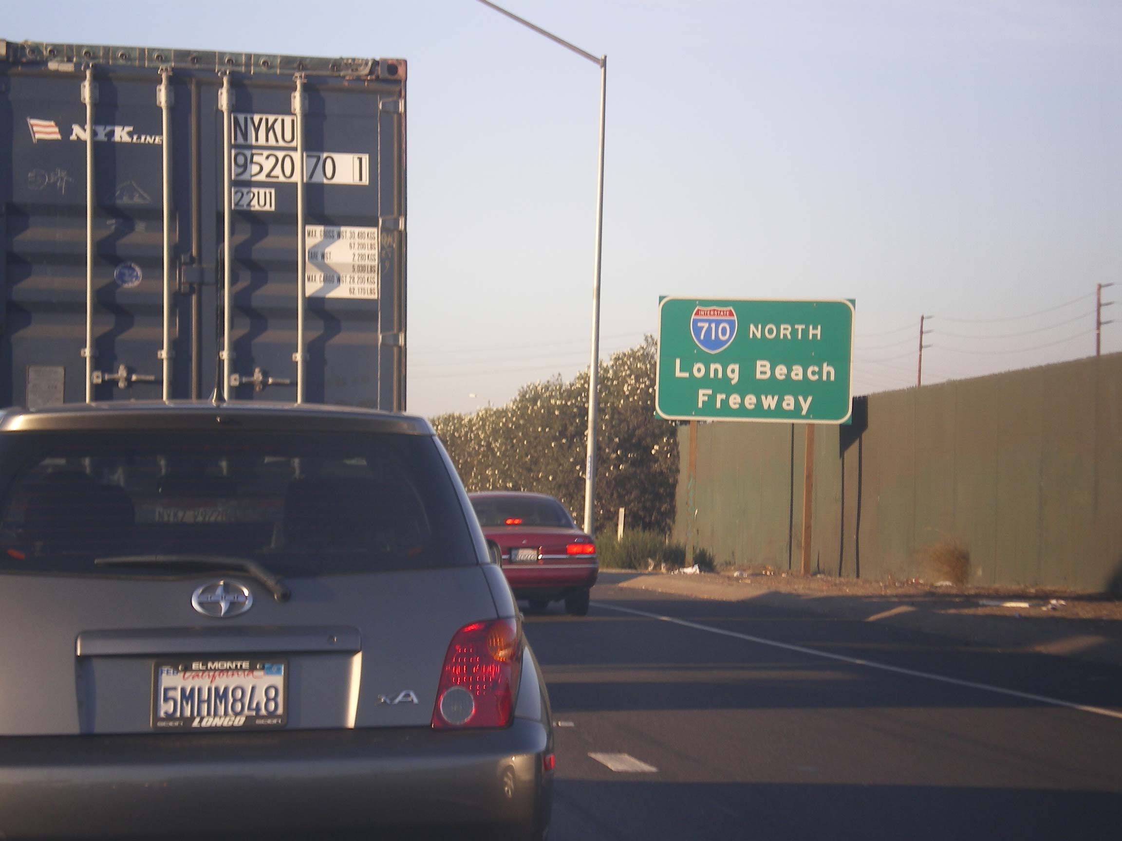 Looking down the Long Beach Freeway Interstate 710 with multiple lanes of traffic and overpasses